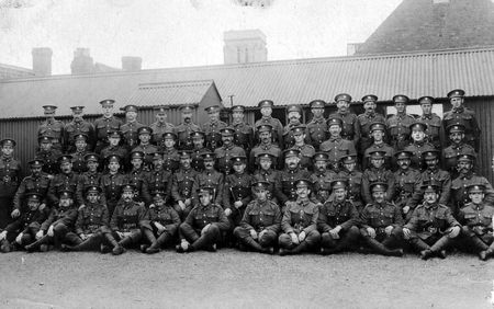 A squad of soldiers - probably recruits to the Herefordshire Regiment - in Friars St Barracks - taken during The First World War. St Nicholas Church Tower in the background.